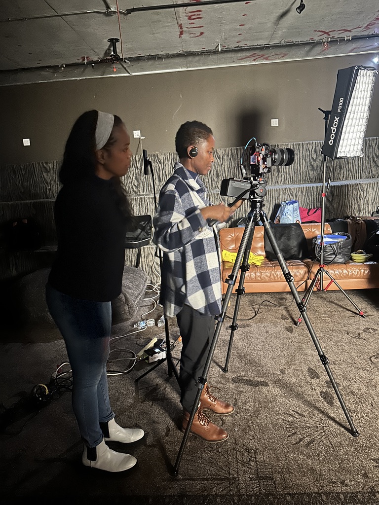 Behind the scenes on a film set, working with a camera on a tripod