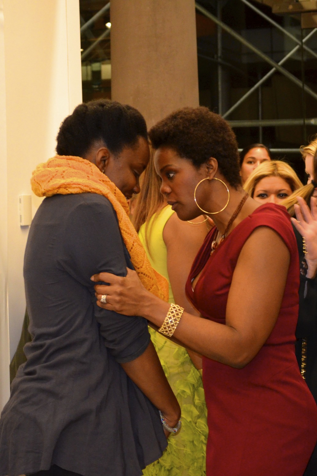 Roz in a red dress sharing an embrace with another actor